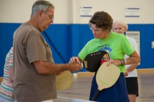 Betsey Cheesman, right, reviews the finer points of gripping a pickleball paddle.