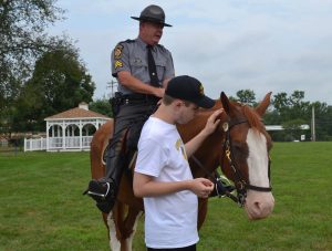 Bryce Rubin, 18, of Lincoln University, makes a new friend, who's ridden by Cpl. Michael Funk