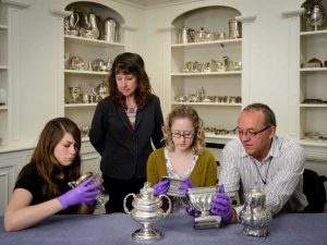 Senior Objects Conservator Bruno Pouliot (from right) works on silver objects with Kaitlin Andrews, a conservation technician; Curator of Decorative Arts Ann Wagner, and Maggie Bearden, a conservation technician during the first phase of the grant-funded project. 