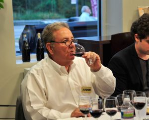 Anthony Stella, of Pagano’s market, sips some red as one of the judges.
