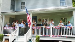 Ten musicians play tribute to Chris Sanderson and the Pcopson valley Boys on the side porch of the Chris Sanderson Museum in Chadds Ford.