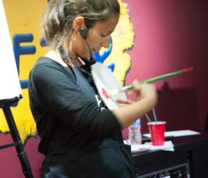 An instructor demonstrates a  technique in which the artist twirls the brush.
