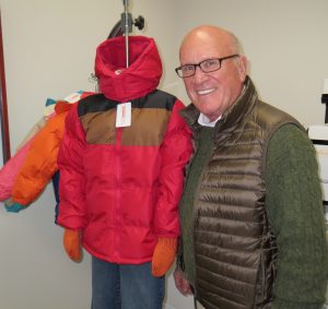 Dick Sanford, the founder of Operation Warm, shows off one of the winter coats destined to keep a needy child from shivering.
