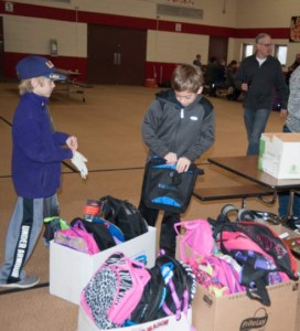 Students at Hallandale Elementary prepare supply-filled backpacks for La Comunidad Hispaña.