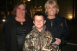 A beaming Alex Collins poses with his mother, Leslie Collins (left), and Chester County Sheriff Carolyn 