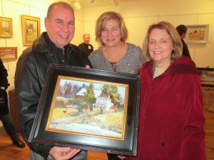 Artist Jacalyn Beam (center) is flanked by Frank and Carolyn McIntosh, who show off the painting by Beam that they had just purchased.