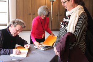 Jamie Wyeth signs a catalogue for Beth and Warren Haas of Wilmington.