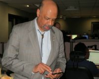 Chester County Commissioners' Chairman Terence Farrell demonstrates the new 9-1-1 texting system implemented by the county. To his right is dispatcher Shana Howard.