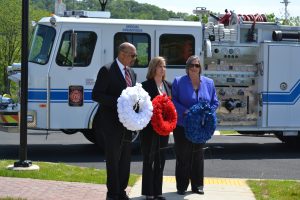 Chester County Commissioners Terence Farrell (from left), Michelle Kichline, and Kathi Cozzone place get ready to place commemorative wreaths at a 9/11 memorial at the county's new Tactical Village in South Coatesville.