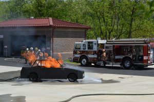 Firefighters quickly extinguish a burning car during a simulation at the new Tactical Village complex.