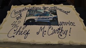 A vanilla cake, featuring lemon and raspberry filling and a photo of the former police chief, helps celebrate Albert J. McCarthy's decades of service. 