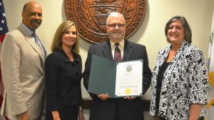 Flanked by Chester County Commissioners Terence Farrell (from left), Michelle Kichline, and Kathi Cozzone (right), Joe Waters, head of Chester County's Domestic Relations Department, displays the proclamation for Child Support Awareness day.