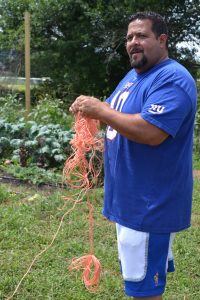 The Chester County Youth Center's Jason Torres accepts the challenge of untangling the twine that will be used for the fall pea crop.