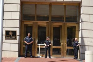 Deputy sheriffs stand guard outside the main entrance of the Chester County Justice Center to prevent people from entering the building. Behind the entrance, detectives were collecting evidence as they investigate Tuesday morning's fatal shooting.