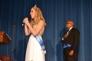 Carly Rechenberg (left), the 2014 Unionville Fair Queen, sings the national anthem as Kennett Square Borough Council President Leon Spencer listens.