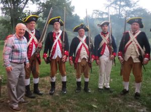 U.S. District Court Judge Berle M. Schiller (left), who served as the event's bartender, poses with the 1st Delaware Regiment Revolutionary Reenactment.
