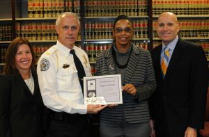 Flanked by Deputy District Attorney Michelle Frei (left) and District Attorney Tom Hogan, West Goshen Police Chief Joseph Gleason receives an award for participating in the LAP program from Dolly Wideman-Scott, CEO of the Domestic Violence Center of Chester County. 