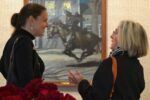 Against the backdrop of one of her great-grandfather's paintings, Victoria Wyeth (left) chats with a guest at the Chester County Art Association, where an exhibit of rarely viewed N.C. Wyeth works is on display.