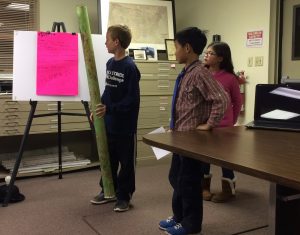 Pocopson Elementary fourth-grader Josiah Hoopman (from left), joined by AHA Moment robotics teammates Chi Xu and Bridget Hoban, offers suggestions to the Pocopson supervisors to eliminate the problems caused by the tubes used to protect tree saplings.