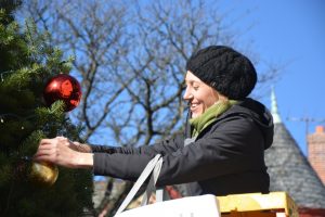 Tara Dugan puts finishes touches on the Kennett Square Christmas tree that anchors a holiday pocket park in the borough's downtown.