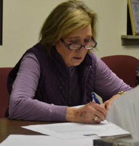 Pocopson Township Supervisor Georgia Brutscher signs bills for the final time during her last meeting on Monday, Dec. 14.