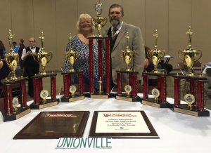 UHS Band Director Scott Litzenberg and his wife, Mary, who heads the color guard, pose with the students' awards.