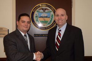 Oscar Rosado (left), the newest county detective, shakes hands with Chester County District Attorney Tom Hogan.