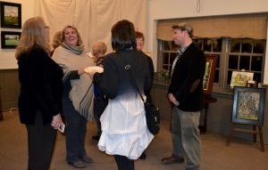 Attendees at the Chadds Ford Historical Society's Plein Air Event mingle with the artists and discuss the paintings.
