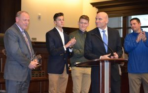 Downingtown Det. Andy Trautmann (left) receives congratulations from District Attorney Tom Hogan (second from right) as well as representatives from Downingtown West High School, including Principal Kurt Barker (right).