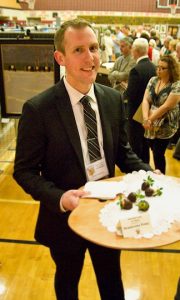 Chadds Ford Elementary School Principal Shawn Dutkiewicz serves chocolate covered strawberries during the open night reception for the art show.
