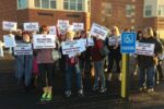 Members of the Garnet Valley Educational Support Professionals Association and their supporters assemble with placards outlining their position on outsourcing before Tuesday night's school board meeting.