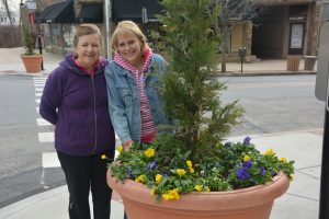 Committee chair Joann Donlick (left) shows off one of the borough's planters with another volunteer.