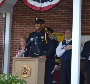 Cpl. Wayne Johnson of the Chester County Sheriff's Office sings the national anthem. To his right is Chester County District Attorney Tom Hogan. On Johnson's left is Donna Dunn, 