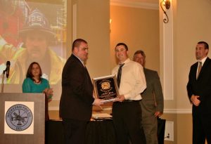 Andrew Yacka (right) receives the McGovern award from Longwood Fire Chief A. J. McCarthy