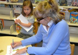 Four-year-old Norah waits as author Margie Palatini signs her copy of 'Perfect Pet.'