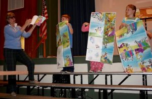 At Unionville Elementary, author Margie Palatini (left) watches as students display the page proofs for one of her books.