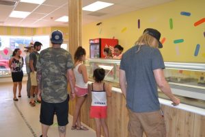 On opening day, a steady stream of customers deliberate over the diverse selection of flavors.