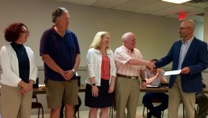 Borough Council President Danilo Maffei (from left) shakes hands with Bill McLachlan, a member of the library board. They are joined by board members Carolyn Nicander Mohr and Jeff Yetter and Library Director Donna Murray. 