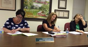 Pocopson Township Supervisors Alice Balsama (from left), Elaine DiMonte and Ricki Stumpo sign bills during their meeting on Monday, June 27.
