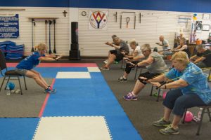 Jackie Tate has seniors use resistance bands for a pushup type of exercise without the need to get done on the floor.