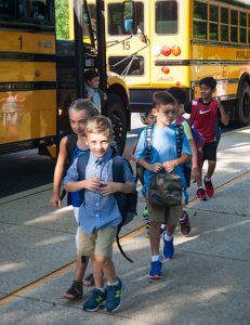 Students get off the buses and walk to class for the first day of the new school year.