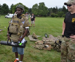 Christoff Abraham, 20, of Coatesville, shows off his SERT gear to his parents as Cpl. Clint Wagner watches.