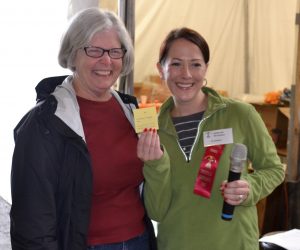 A beaming Susan Snyder (left) accepts her Cow Pie Bingo prize from Deb Deckman, the fair board's president.