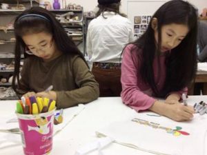 Brianna Yang of Garnet Valley (left) and Elizabeth Cocchiarale of Parkside (right) participate in an art project at the back-to-school party.