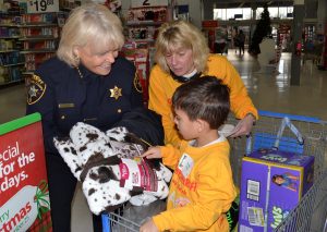 Chester County Sheriff Carolyn 'Bunny' Welsh (left) holds up an item for a shopper's inspection as Sue Flynn, the school's executive director, looks on.