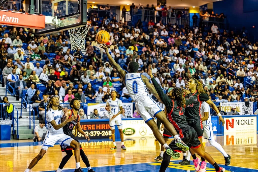 Howard senior Nicholas Baysah finishes at the rim with his left hand. Photo Credit: Dave Reeder